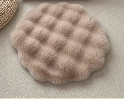 Round, textured beige cat rug mat on a neutral surface