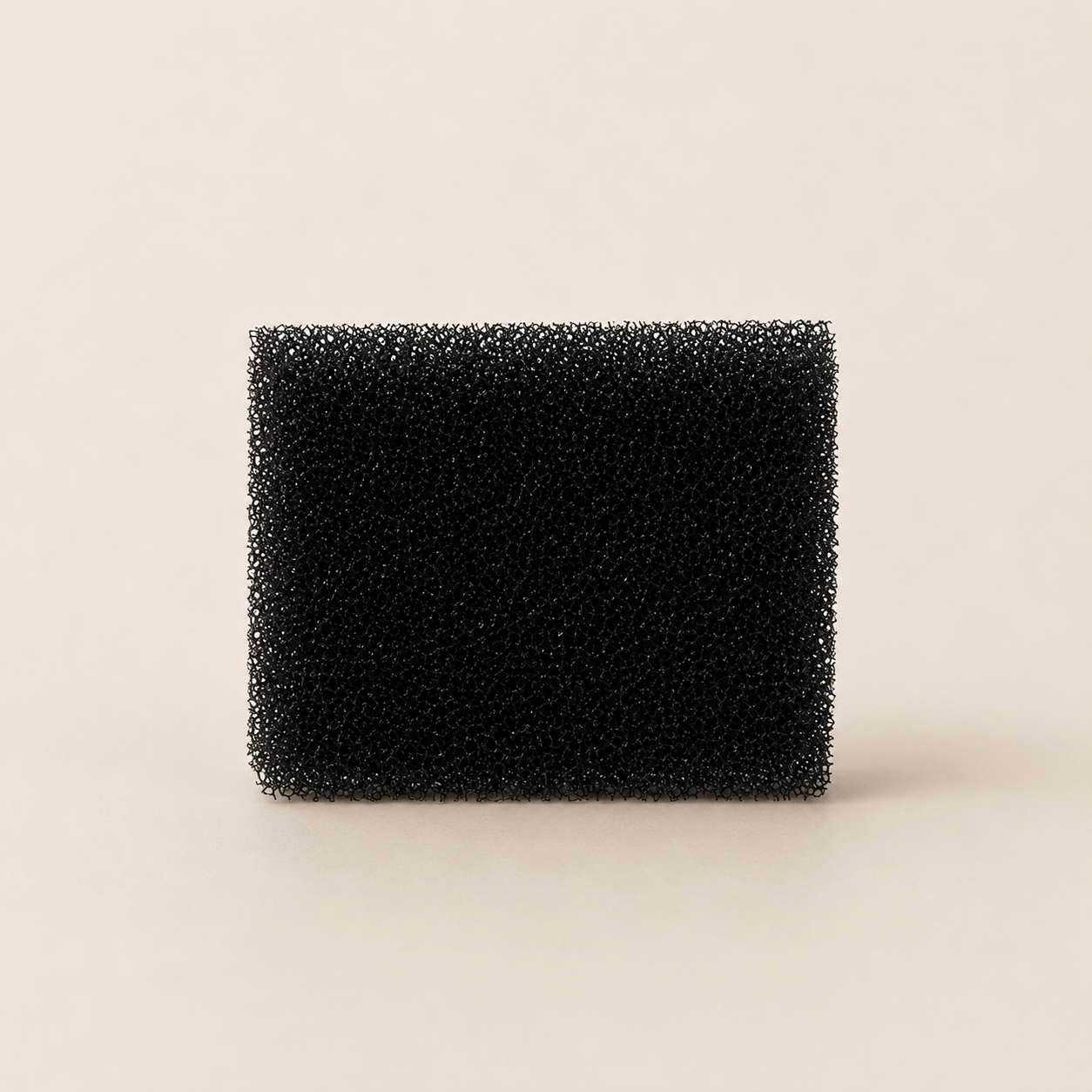Black rectangular foam filter on a beige background