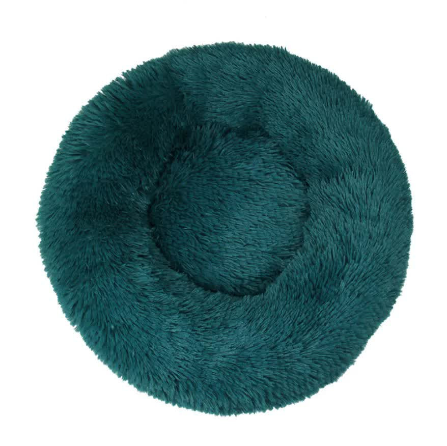 Teal circular fluffy pet bed on a white background