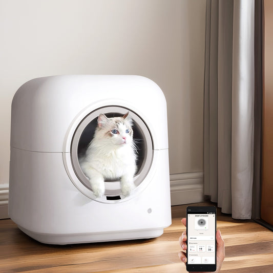 White pet automatic smart litter box with a cat inside, held by a person using a smartphone app.