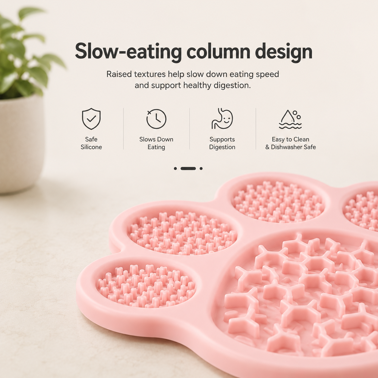 A pink slow-feeding pet mat with raised textured sections and a large patterned bowl area, shown on a light surface with marketing text above and a small plant in the background.