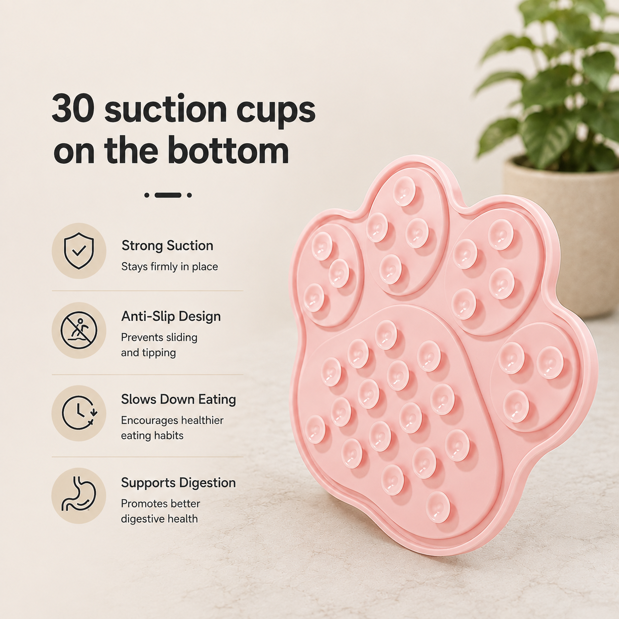 Pink paw-shaped suction cup mat shown on a light marble surface with a potted plant in the background. Text on the left highlights features like 30 suction cups on the bottom, strong suction, anti-slip design, slowing down eating, and support for digestion.