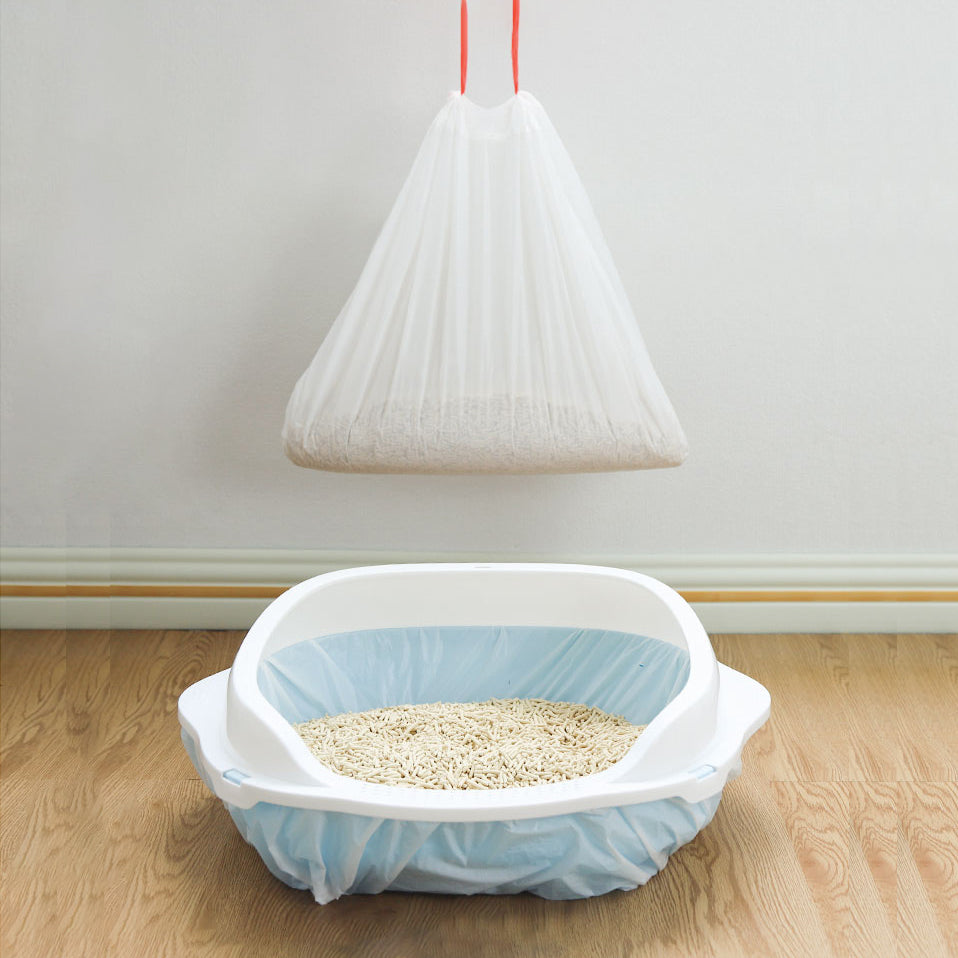 Pet litter box with a closed litter liner bag over it on a wooden floor.