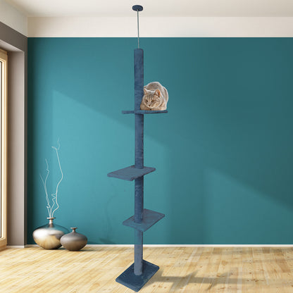 Cat climbing tower against a teal wall with a cat perched on one of the shelves.