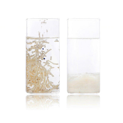 Two clear glass containers displaying cat litter on a white background