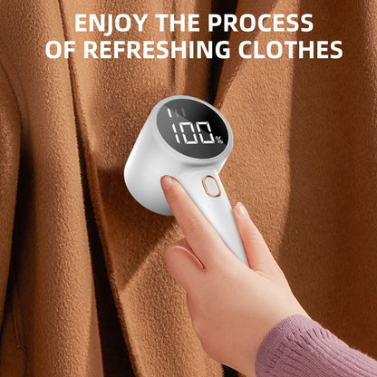 Hand holding a digital automatic pet hair remover against a brown fabric background with text 'Enjoy the process of refreshing clothes'.