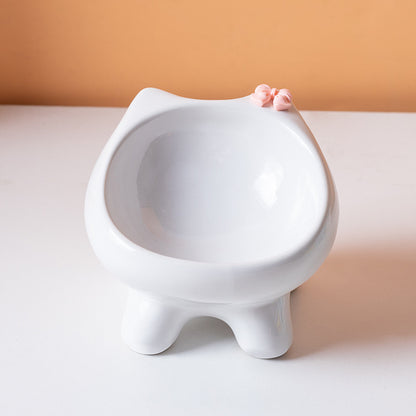 White cat-shaped cat bowl on a white surface with a beige background