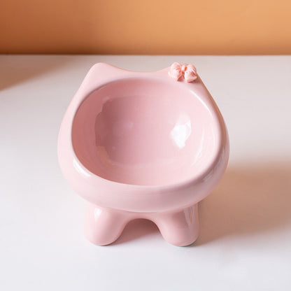 Pink ceramic cat bowl shaped like a cat on a white surface with a beige background