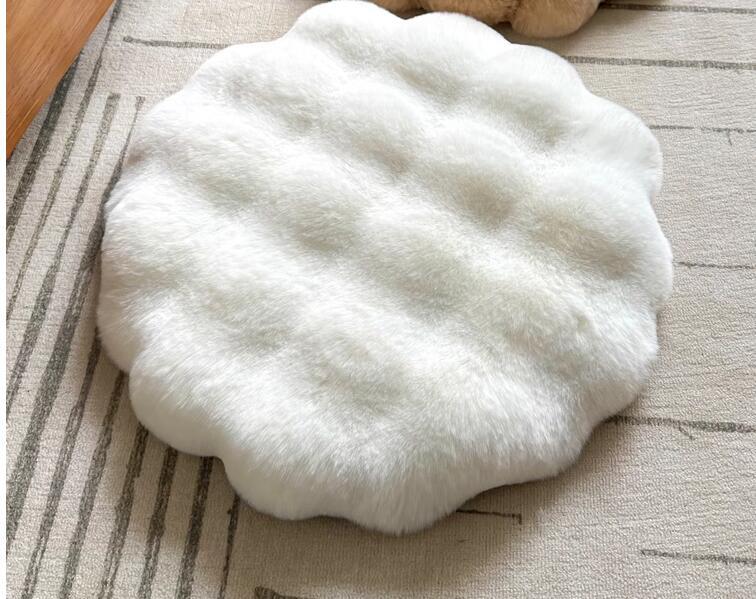 White fluffy cat cushion mat on a textured surface