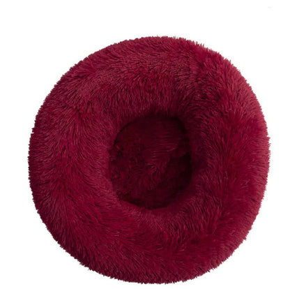 Red fluffy donut-shaped pet bed on a white background